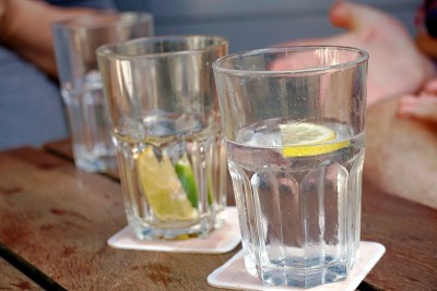 在户外餐厅的桌子上放上一杯水、柠檬和酸橙片。