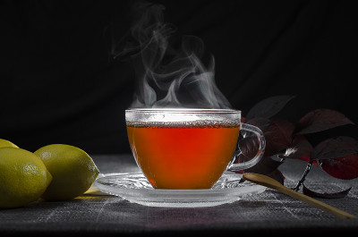 用玻璃杯盛热茶，配以柠檬和香草。随意的背景。茶，咖啡，热饮，