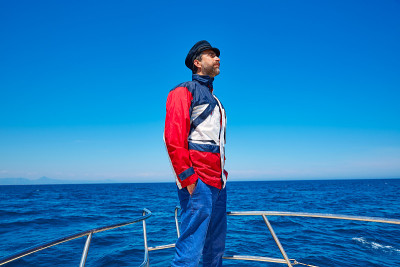 胡子水手帽男人在一艘小船上航行大海