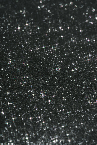 抽象的黑色背景与闪烁的星星的形状。