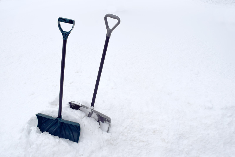 雪堆里的雪铲在寒冷的冬天白色的暴风雪