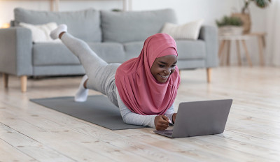 Sporty black muslim woman doing plank in front of 