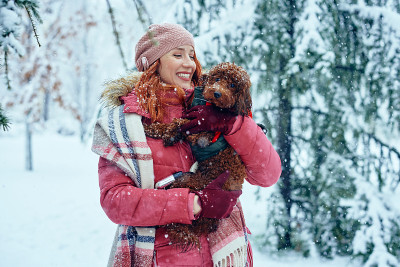女人和狗在下雪的冬天
