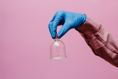 真空泵和罐的hijama。武器。在粉红色的背景上