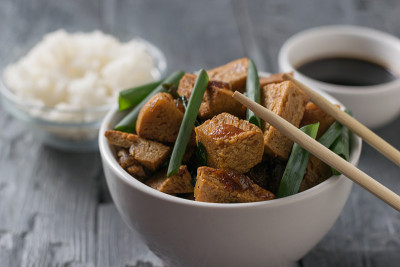 烤豆腐、奶酪、米饭和酱油放在一张木桌上。