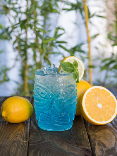 木桌上放着夏日提基鸡尾酒