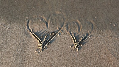 在沙滩上画心形，日落时被海浪抹去