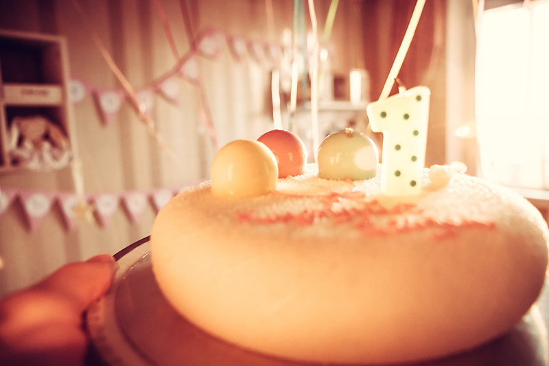 快乐生日蛋糕为儿童聚会装饰一个蜡烛和甜蜜的气球在庆祝一周年生日作为快乐的生日背景