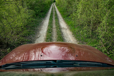 Off road car hood perspective on dirt road in fore