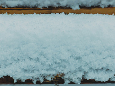 雪躺在长凳上。雪落在城市的街道上。立冬