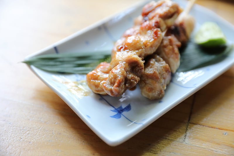 日式料理，烤鸡肉串在木头背景上