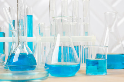 试管中装有蓝色液体的实验室玻璃器皿。科学实验室烧瓶，滴管，培养皿，烧杯和圆筒，实验室设备