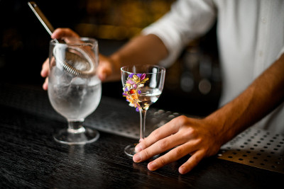 酒保用滤网从玻璃杯里倒酒