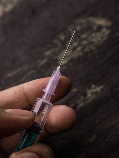 类固醇与注射器和人手对纹理背景库存图像的副作用。