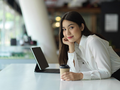 职场女性手捧纸杯微笑的侧面图