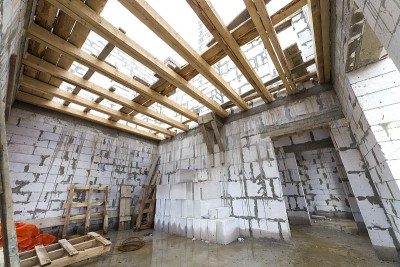 房屋内部正在建设和翻新。中空泡沫保温砌块、木质天花板梁、屋面框架等节能墙体。