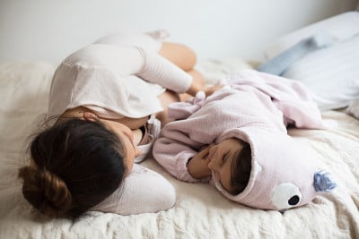 一个孕妇和她的女儿一起躺在床上。