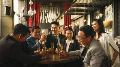 在商务俱乐部和酒廊举行的商务聚会上，亚洲商务人士聚在一起畅饮葡萄酒或香槟，畅谈友谊