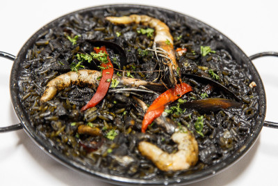 黑色意大利调味饭配海鲜在白色盘子，arroz negro来自西班牙