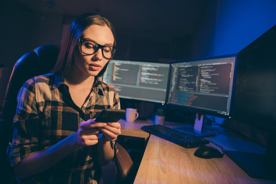可爱的女孩戴着眼镜在新一代信息技术使用javascript的创业和项目工作的照片
