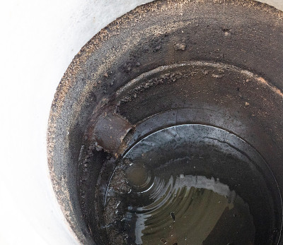 水从厕所的混凝土化粪池的排水管中流出
