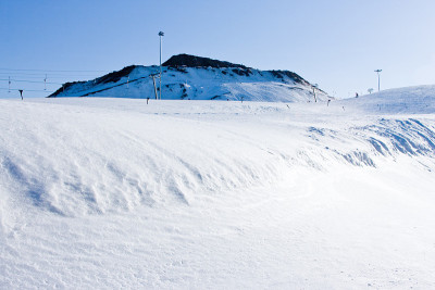 日落时空旷的滑雪场。从积雪覆盖的斜坡上下来。