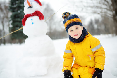 小男孩在玩有趣的雪人。冬季与孩子们一起进行户外活动。