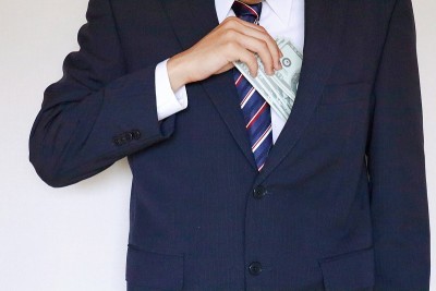 穿着西装的男人拿着美元