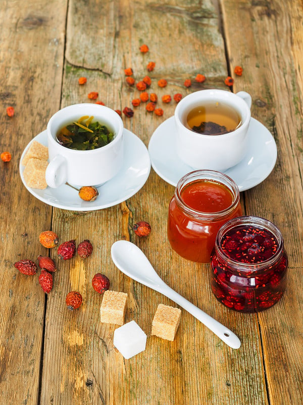 Two cups of tea and jam on a wooden table. Tea in 