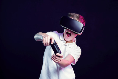 男孩戴着VR眼镜玩游戏手柄