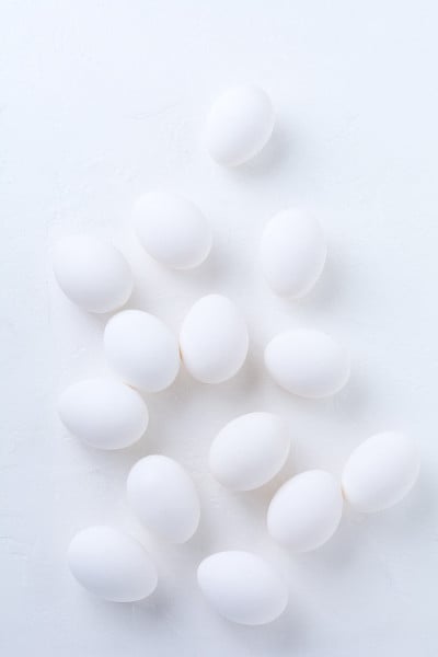 白色的生鸡蛋躺在浅混凝土背景下。前视图。
