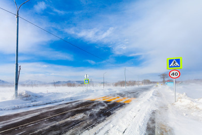冬季，大雪、暴风雪、暴风雪和能见度差的道路上有人行横道、公交车站和路标。开车时路上下雪很危险。