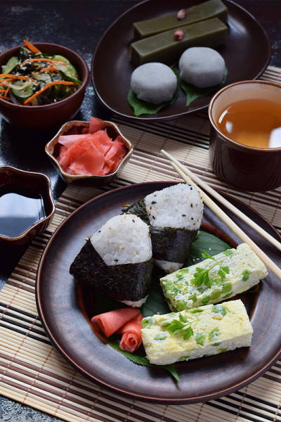 混合日本食物-饭团饭团，煎蛋卷，生姜，日式裙带菜黄瓜沙拉。传统的豆和绿茶抹茶甜品-果冻洋芋，大福麻糬