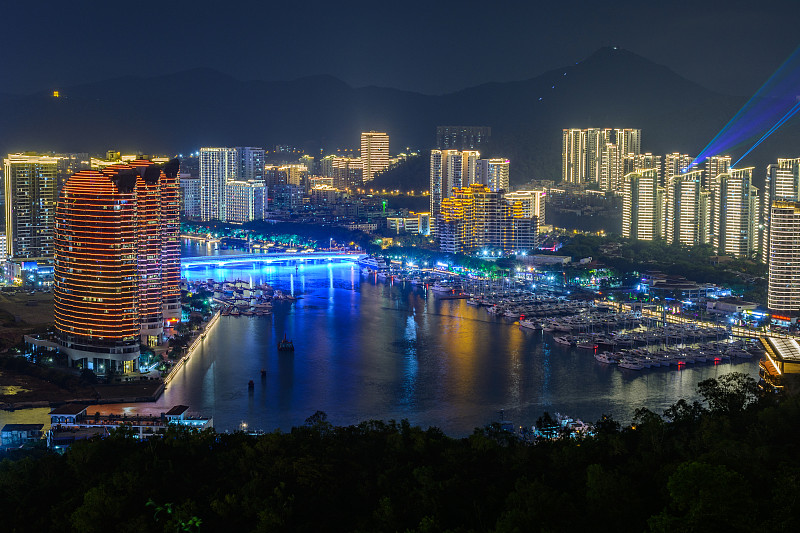 夜景三亚市与明亮的彩色照明建筑，结构，道路，人行道，杆子，桥梁。