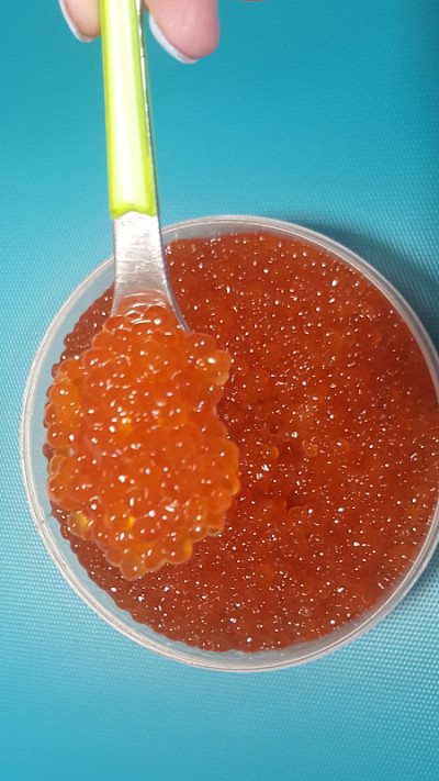 勺子上的红鱼子酱。健康食品。鱼开胃菜