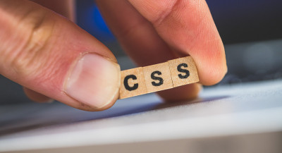 CSS网络语言:在笔记本电脑上放置一个带有字母“CSS”的木制立方体，这是样式表语言的概念