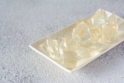 明胶，琼脂，在灰色背景上的凝胶块(晶体形式的立方体)。烹饪、糖果制品用胶凝剂(胶原蛋白)。