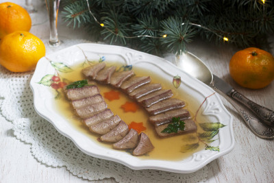 用煮过的胡萝卜和欧芹装饰舌头的肉冻，在节日的背景下。乡村风格。