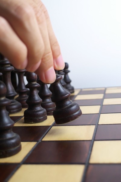 手和木制棋盘，孤立在白色背景
