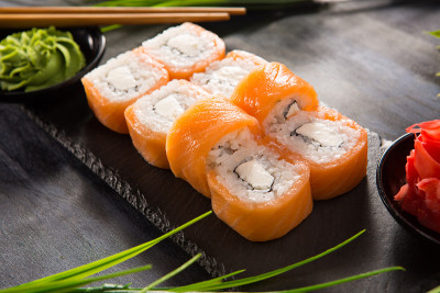 一套寿司卷与芥末和生姜在黑色的背景。日本东方美食