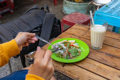 女游客吃越南街头食品- Banh Cuon