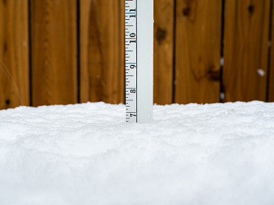 尺测量七英寸的雪。