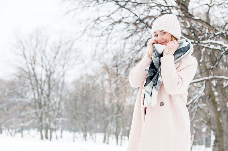 年轻女子在一个满是雪的公园里