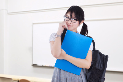 可爱的女学习者站在教室里