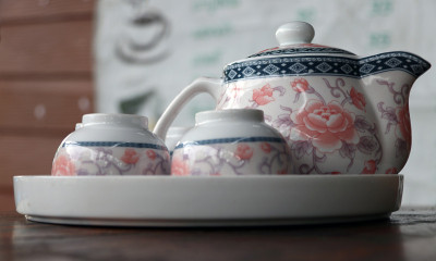 花式茶具放在木桌上。一套杯子和壶。