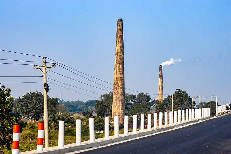 高速公路旁有两家老砖厂，烟囱里飘着浓烟，电线杆上挂着电线