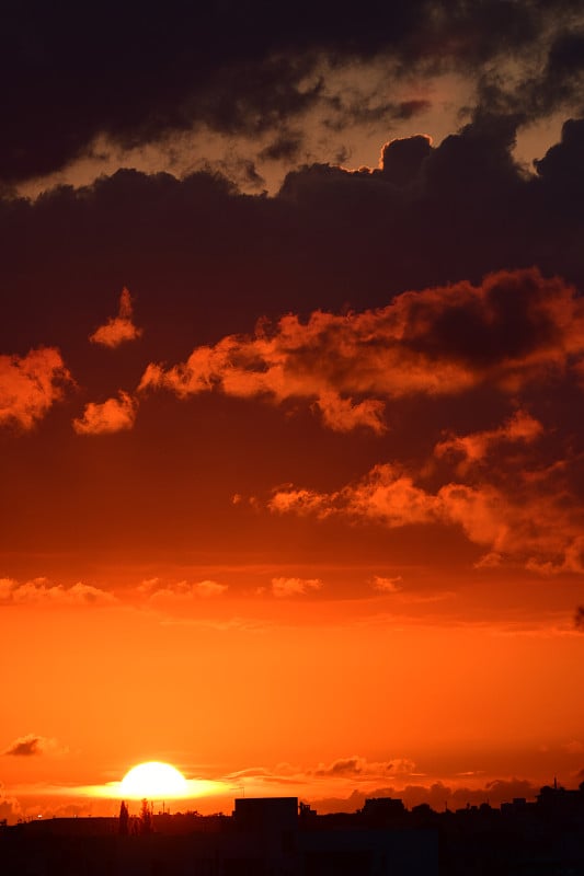 橙色的日落与太阳穿过云层在地平线上