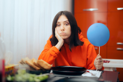 悲伤的女人拿着气球独自度过她的生日