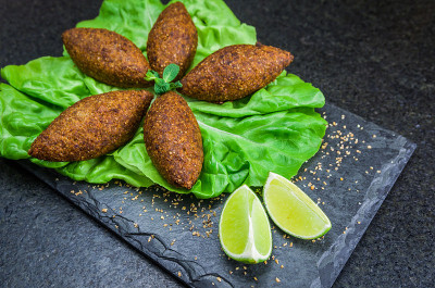 美味的黎巴嫩(阿拉伯)食物，kibbeh (kibe)在黑色板岩和花岗岩背景。