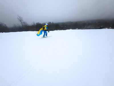 一位年轻的女子从雪坡上滑下来